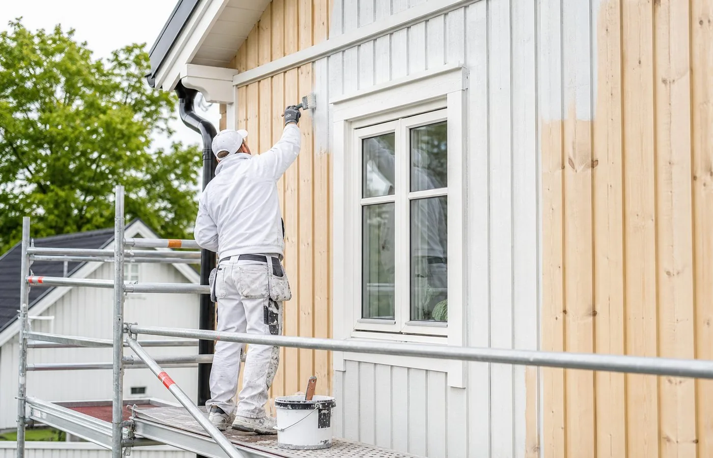 Målare arbetar med fasadmålning
